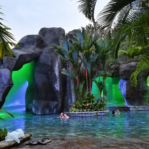 Cascadas de roca iluminadas sobre una poza termal