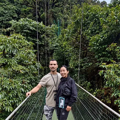 Pareja en un puente colgante de Treetopia, entre el bosque